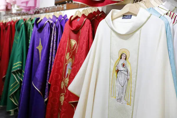 Chasubles for priest with religious symbols embroderies for sale in a shop.  Ho Chi Minh City. Vietnam.