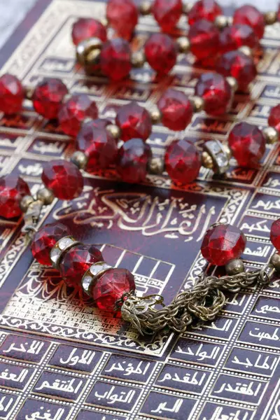 Prayer beads and the cover of the Holy Quran (Koran) with the  99 names  of Allah in arabic calligraphy. Religious text.
