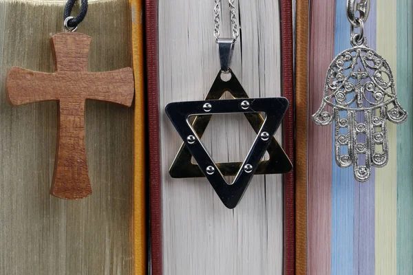 Religious symbols. Quran, Bible and Torah. Christian cross, star of David and hand of Fatima. Christianity, Islam and judaism. Interfaith and interreligious dialogue concept.