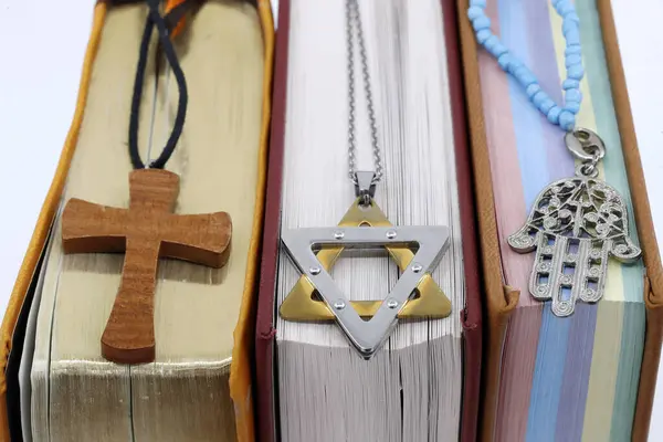 Religious symbols. Quran, Bible and Torah. Christian cross, star of David and hand of Fatima. Christianity, Islam and judaism. Interfaith and interreligious dialogue concept.