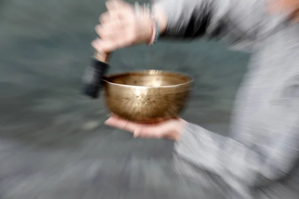 Tibetan bowl is used in sound therapy, meditation and yoga. Woman practicing a singing bowl for sound therapy in atmosphere for healing, meditation and relax.  France.
