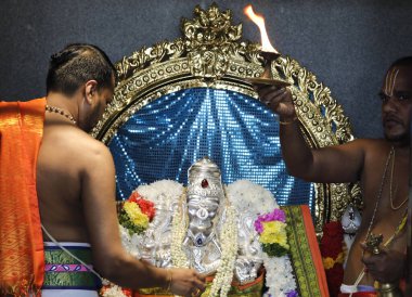 Sri Srinivasa Perumal Hindu tapınağı. Hint Hindu Fil Tanrısı Ganesh (Ganesha veya Ganapati). Hindu rahip (Brahmin) puja töreni yapıyor. Singapur. 