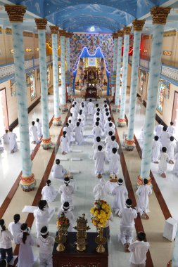 Cao Dai tapınağı. Kaodaist ibadetçiler seremonide. Tan Chau. Vietnam.