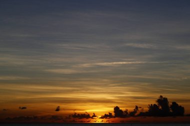 Gün batımında Karayip Denizi. Bulutlu turuncu gökyüzü. Cennet doğası. Cayman Adaları. 