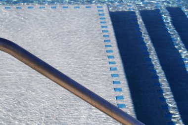 Soyut yüzme havuzu mavi su, fayanslar ve merdivenler. Cayman Adaları. 