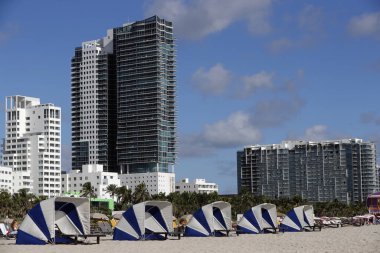 Salon sandalyeleri sabah Miami Beach 'te bir otelde sıraya girdiler. Yüksek binalar mimarisi. Miami, Florida, ABD.