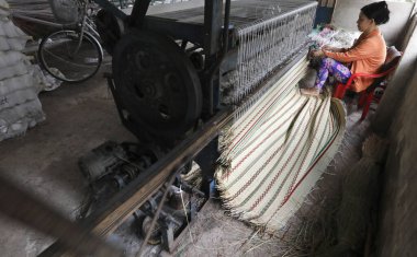 Geleneksel bambu ve kenevir paspas fabrikası. Vietnamlı kadın dokuma tezgahı üzerinde çalışıyor. Tan Chau. Vietnam.