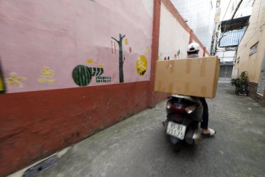 Motosikletle teslimat. Sokakta bir sürü motosikletli paketi olan bir motosikletli. Ho Chi Minh Şehri. Vietnam.