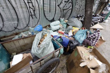 Bir kadın sokakta plastik çöp ve şişe topluyor. Ho Chi Minh Şehri. Vietnam.