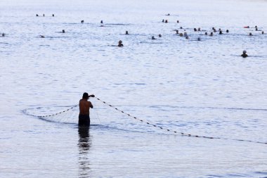 Balıkçı ağıyla balık tutmaya çalışıyor. Vung Tau. Vietnam.