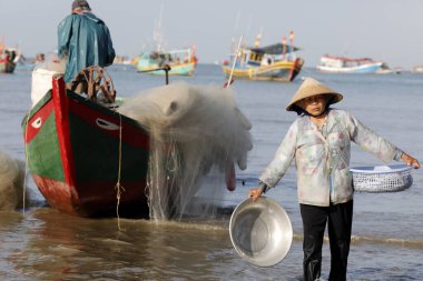 Dua Koyu 'nu asın, balıkçı tekneleri. Balık tutan kadın. Vung Tau. Vietnam.