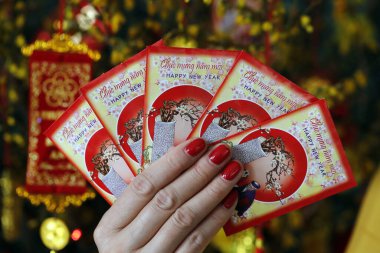 Çin ve Vietnam 'ın yeni yıl kutlamaları için kırmızı zarflı Asyalı kadın. Kırmızı renk iyi şansın sembolüdür. Fransa. 