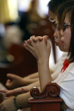 Bu Nghe Katolik Kilisesi. Kutsal hafta. Bir Katolik kilisesinde Palm Sunday kutlaması. Dua eden kadın. Ho Chi Minh şehri. Vietnam. 