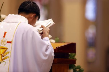 Aziz Nicholas Katedrali Dalat. Pazar ayini. Cazibeli rahibin arka görüntüsü. Kelimenin Edebiyatı. İncil kitabı. Dalat. Vietnam. 