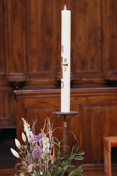 Paschal candle is a large white candle used every year at Easter. Cruseilles. France.