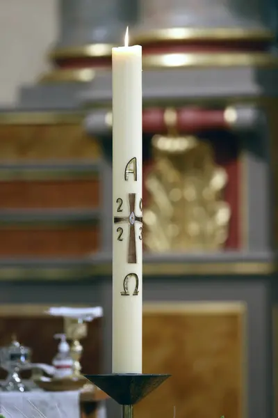 Paschal candle is a large white candle used every year at Easter. Cruseilles. France.