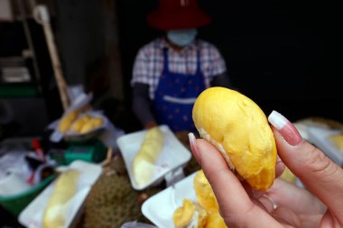 Bir kadın Durian meyvesini satılığa çıkarıyor. Sokak yemekleri hem turistler hem de yerel halk arasında popülerdir. Bangkok 'ta. Tayland. 