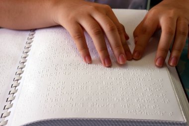 Kör çocuklar için merkez. Kör kız Braille kitabı okuyor. Yakından bak. Ho Chi Minh şehri. Vietnam. 