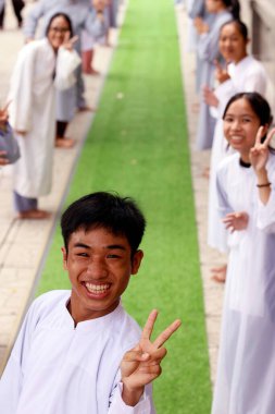 Phuoc Hue Budist tapınağı. Budist töreninde gülümseyen genç bir çocuk. Vietnam. 