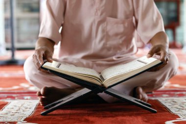 Mübarek camii. Mescid-i Haram 'da oturan ve Kuran' ı okuyan müslüman bir adam. Vietnam. 