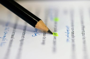 Kağıt belge metni üzerindeki kalemin yakın görüntüsü.