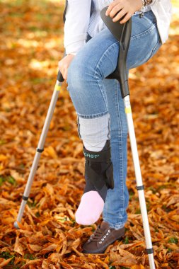 Genç kız ve koltuk değnekleri. Engellilik.