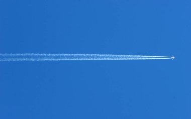Mavi gökyüzünde bir uçağın uyanışı. Seyahat ve hava taşımacılığı. İtalya. 
