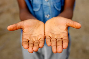 Yıkadıktan sonra ellerini gösteren bir çocuk. Okulda hijyen. Togo. 