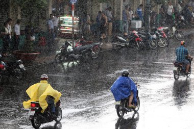 Şiddetli muson yağmurları. Saigon Caddesi 'ndeki motorlu scooterlar. Vietnam. 