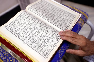 Kuran okuyan Müslüman bir adam. Mescid Mirasuddeen camii. Bangkok 'ta. Tayland.