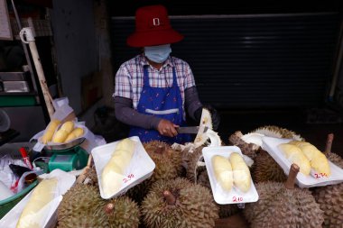 Bir kadın Durian meyvesini satılığa çıkarıyor. Sokak yemekleri hem turistler hem de yerel halk arasında popülerdir. Bangkok 'ta. Tayland. 