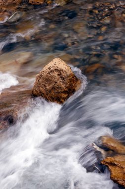 Dağ nehri kayaların üzerinden akıyor. Nehrin dibi taşlı. Şelaleler çağlıyor. Les Contamines. Fransa. 