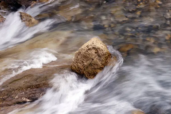 Dağ nehri kayaların üzerinden akıyor. Nehrin dibi taşlı. Şelaleler çağlıyor. Les Contamines. Fransa. 