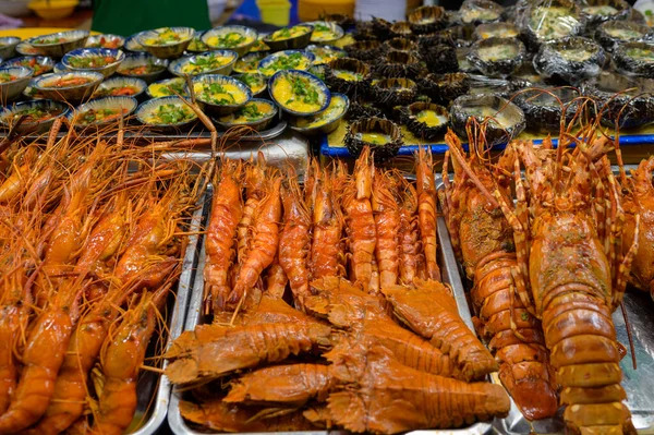 High angle heaps of spiny lobsters placed in containers on stall in local market in Vietnam