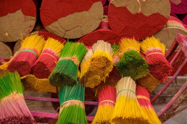 Yüksek açılı renkli tütsü çubukları ve Vietnam 'da üretilen pembe metal arabalara takılan kurdeleler.