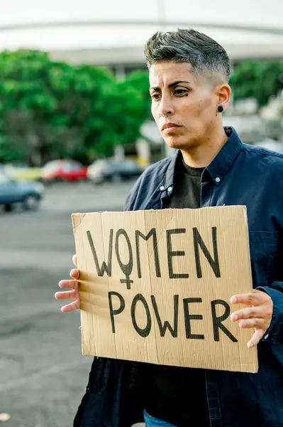 严肃的女性 留着短发 展示女性的权力标牌 站在街上望着别处 在公园里抗议女性 — 图库照片