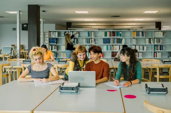 Grupo Estudiantes Multirraciales Sentados Mesa Biblioteca Mirando Pantalla Computadora Portátil —  Fotos de Stock