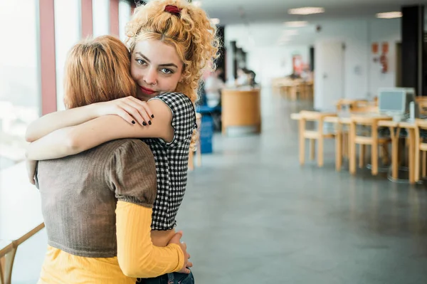 Kıvırcık Sarı Saçlı Kız Arkadaşını Kucaklayan Üniversite Kütüphanesinde Birlikte Vakit — Stok fotoğraf