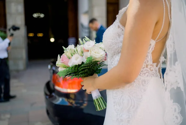 Неузнаваемая Невеста Белом Платье Кучей Свежих Цветов Стоящих Возле Машины — стоковое фото