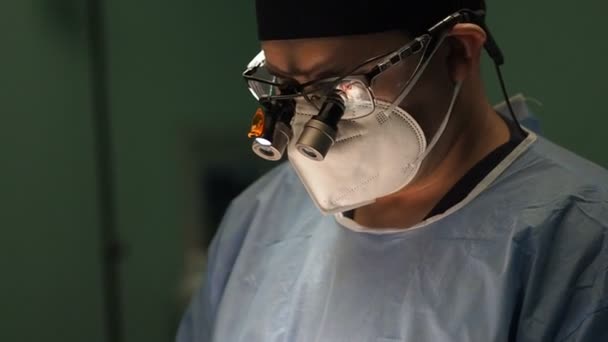 Ręczne Ujęcie Męskiego Lekarza Masce Twarz Lupy Chirurgiczne Pracującego Przyciemnionej — Wideo stockowe
