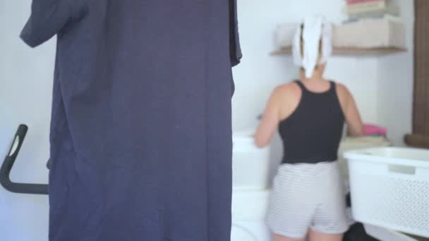 シャワー後にドライクリーンなタオルと成熟した女性の荷降ろし洗濯バスケットのラックフォーカスでズームと離れる — ストック動画