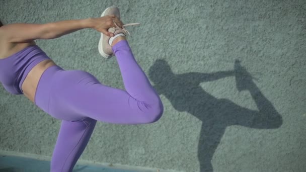 在阳光下 穿着运动服的女人站在水泥墙边做俯卧撑瑜伽时 镜头放大 — 图库视频影像