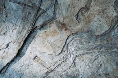 Düz olmayan çatlaklar ve göçüklerle kaplı pürüzlü doğal taş yüzeyinin dokulu arka planı