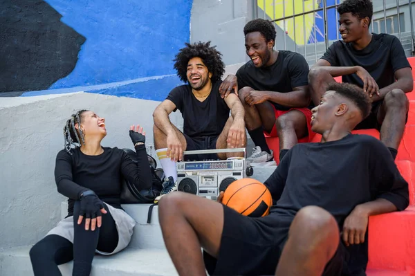 一群兴高采烈的非洲裔美国篮球运动员穿着运动服 坐在楼梯上 头戴复古盒式磁带 面面相觑 — 图库照片