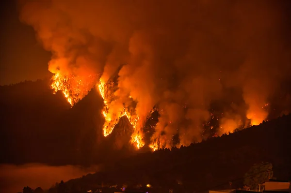 İspanya 'nın Kanarya Adaları' ndaki Tenerife 'de gece vakti dumanla kaplı yanan Teide sıradağlarının muhteşem manzarası.
