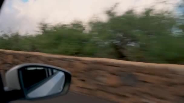 Tenerife农村地区的实车从带有后视镜和绿树成荫的轿车乘客座位窗口射击 在阳光下迎面而来的是汹涌的蓝天 — 图库视频影像
