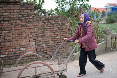 Gündelik giysiler ve tesettürlü genç Müslüman bir kadın şehrin caddesinde scooter sürüyor.