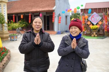Sıcak elbiseli neşeli genç bayan sokakta dikilip kameraya bakıyor.