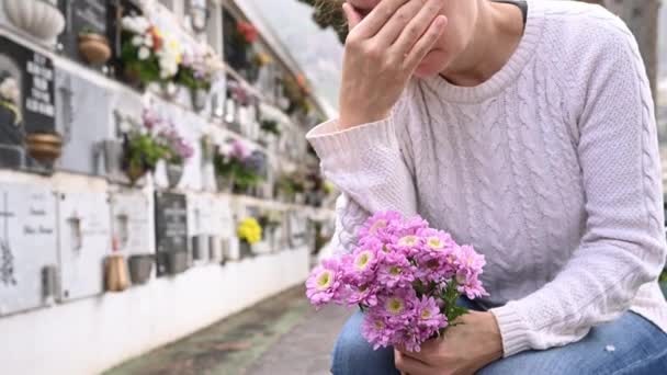 Жінка Повсякденному Одязі Плаче Торкається Голови Сидячи Біля Могильної Стіни — стокове відео