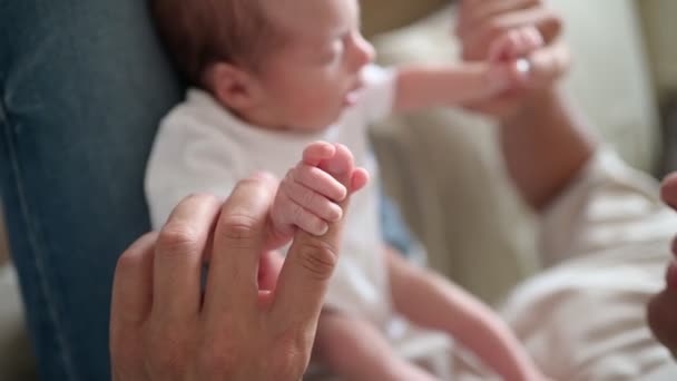 Soft Focus Handheld Shot Infant Onesie Grasping Finger Dad Sitting Video Clip